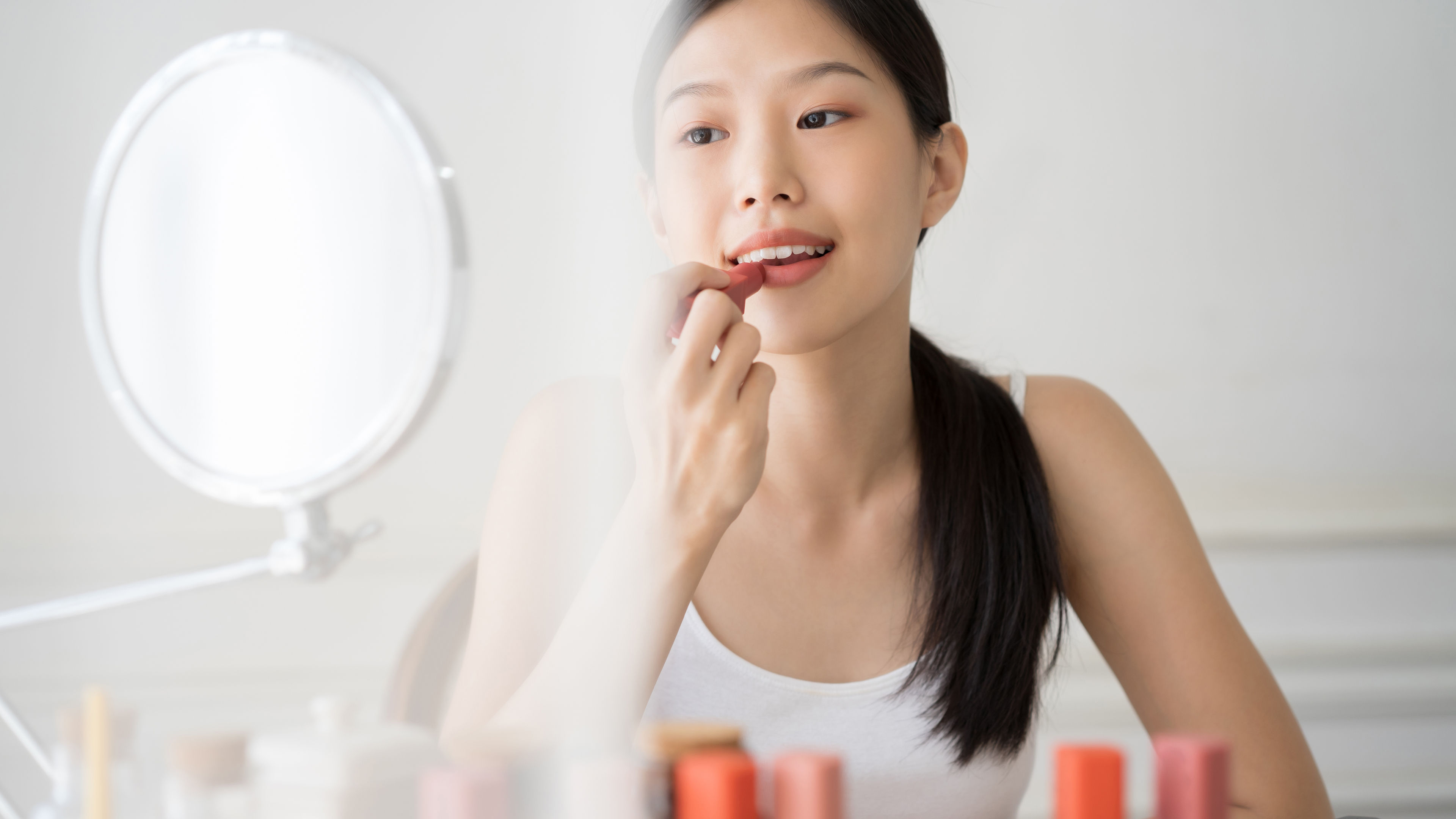 Asian girl is using lipstics