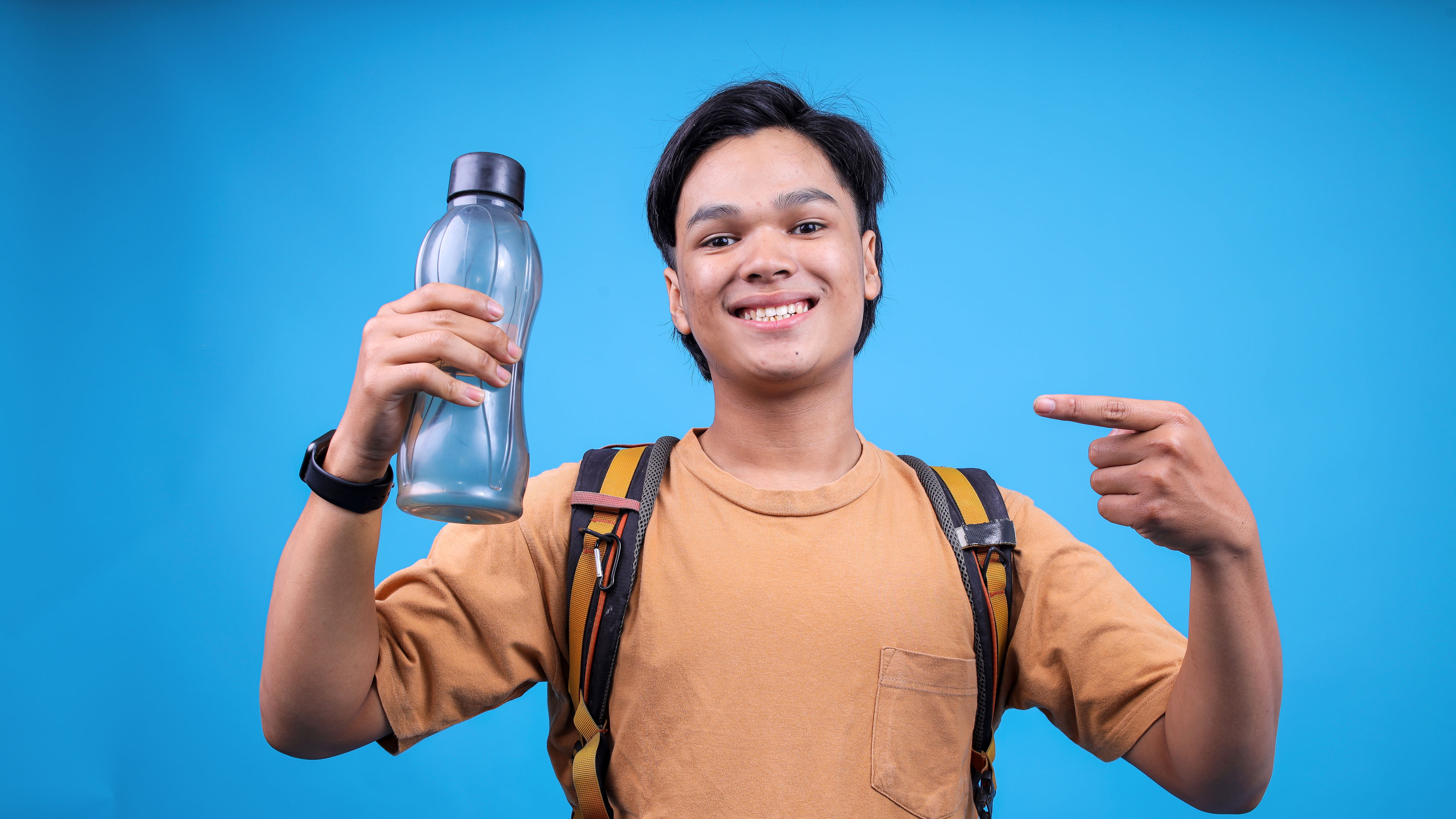 A young Asian man with a bottle in hand