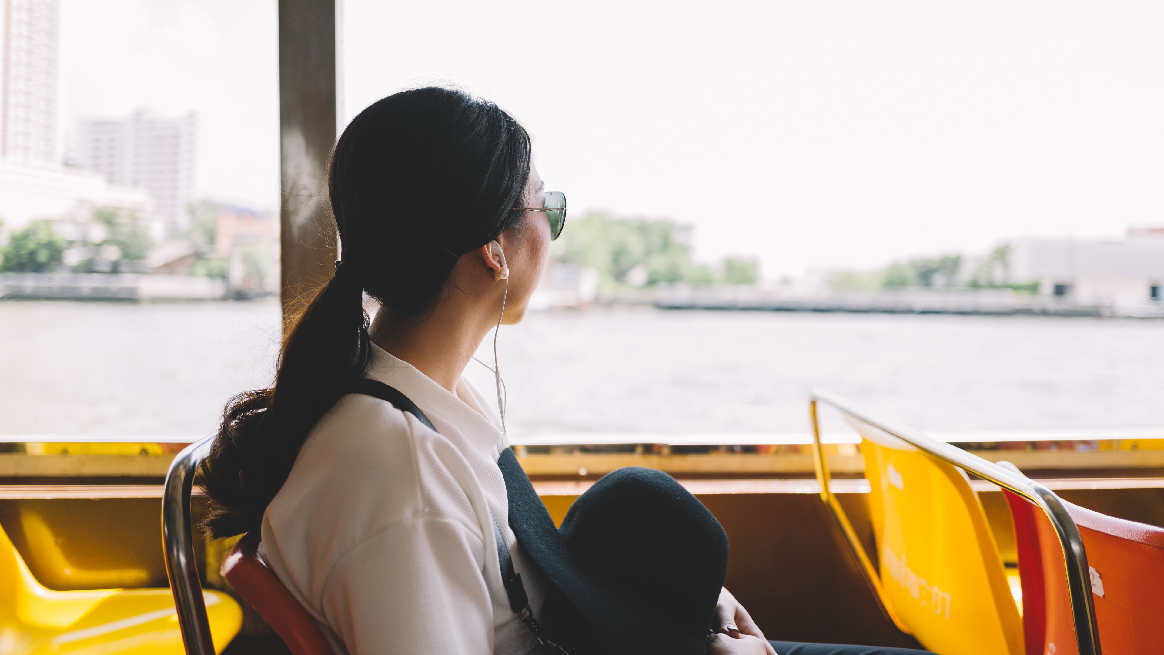 Asian woman on a boat listening to music