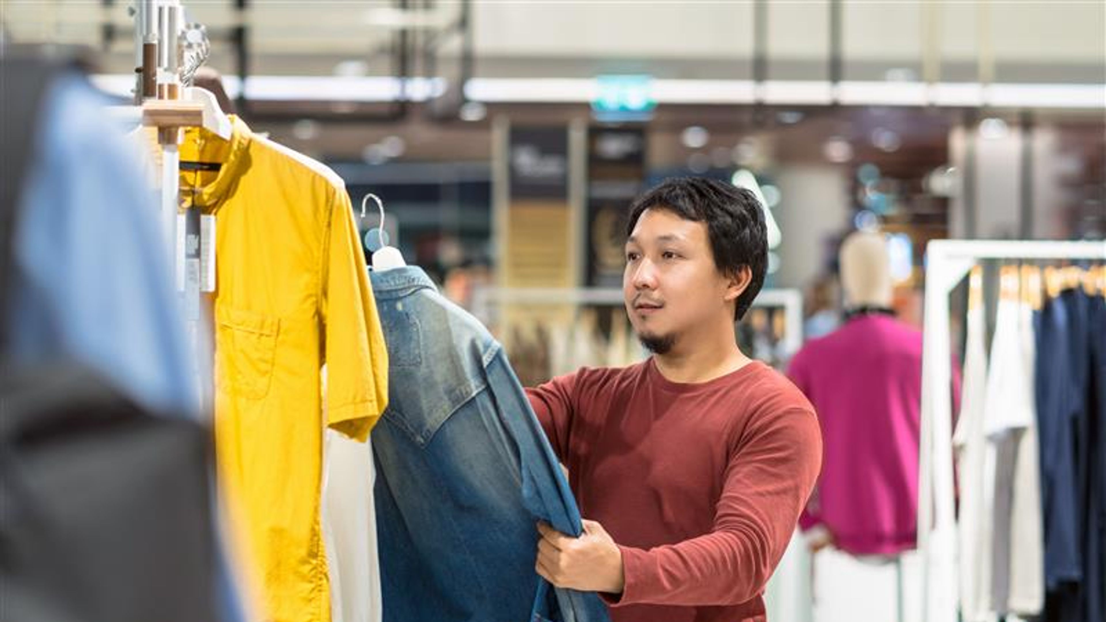 Smart asian man choosing clothes