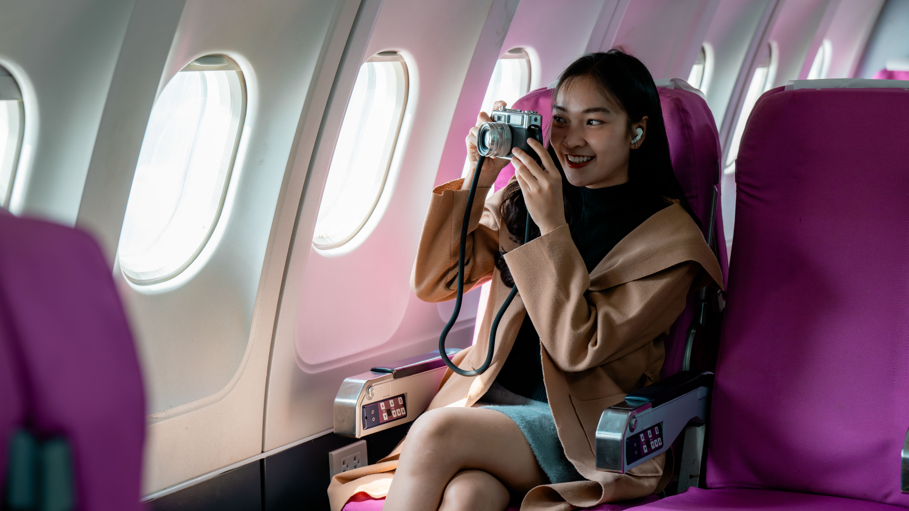 Tourist taking pictures with analog camera while travelling by plane