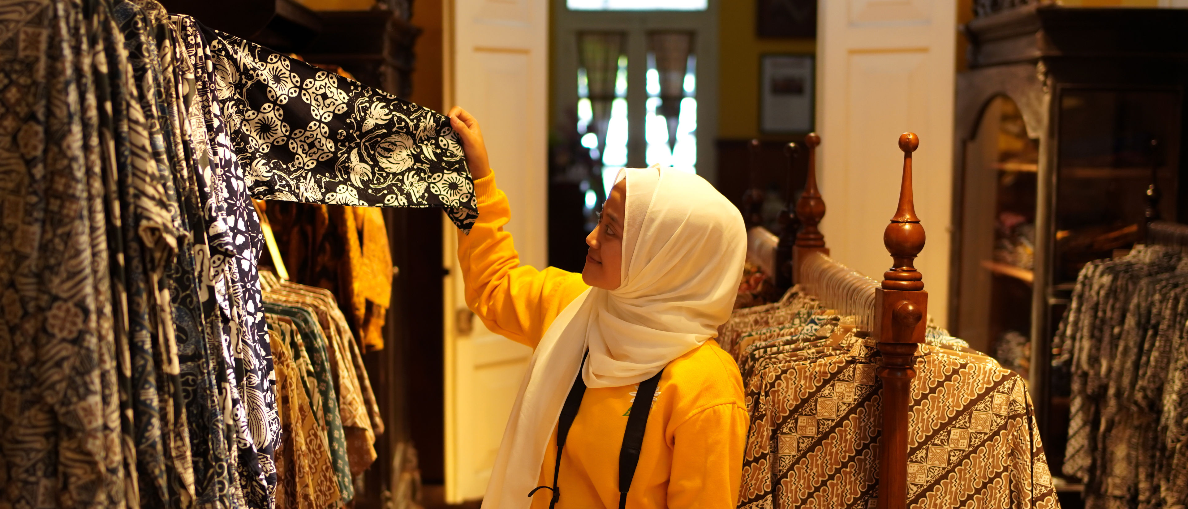A woman choosing dresses in a shop